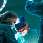 Ameliyathane ışıkları altında operasyon yapan cerrahi ekip